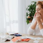 Uncertainty Finance - Woman Crying and Dollar Bills with Receipts on Desk