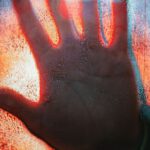 Risks Rewards - Hand Touching Glass