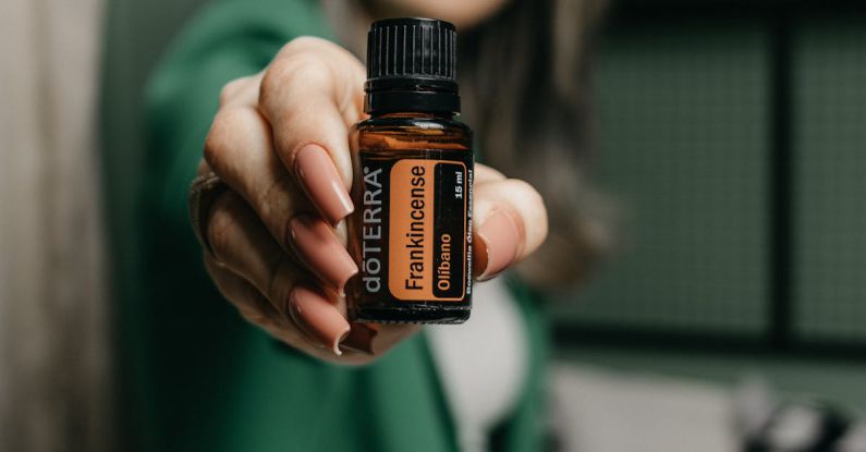 Company Valuation - A woman holding up a bottle of essential oil