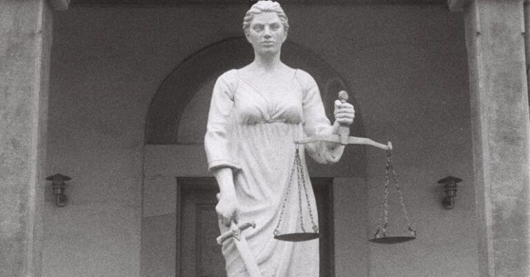 Antitrust Law - A statue of a woman holding a scale in front of a building