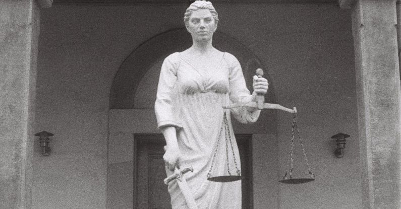 Antitrust Law - A statue of a woman holding a scale in front of a building