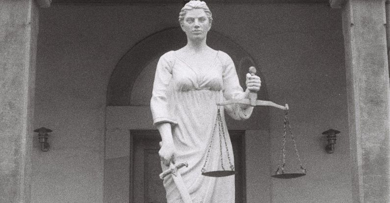 Antitrust Law - A statue of a woman holding a scale in front of a building
