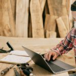Remote Work - Man Using a Laptop at a Wood Workshop
