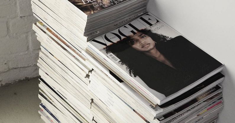 E-commerce Trend - High angle many fashion magazines stacked on floor against white brick wall in studio