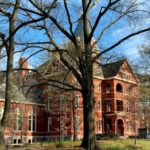 Saving College - A large red brick building with trees in the background