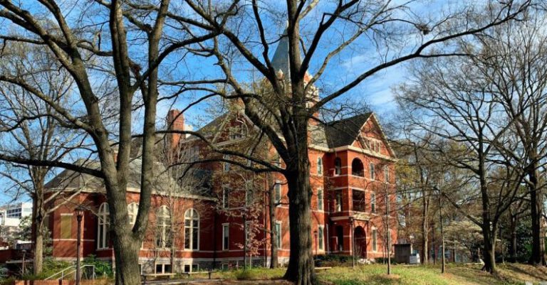 Saving College - A large red brick building with trees in the background