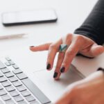 Biotech Startup - Crop female using touchpad on laptop in office