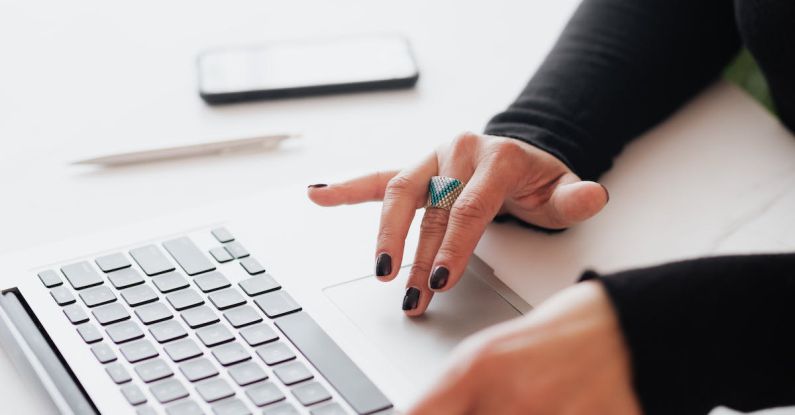 Biotech Startup - Crop female using touchpad on laptop in office