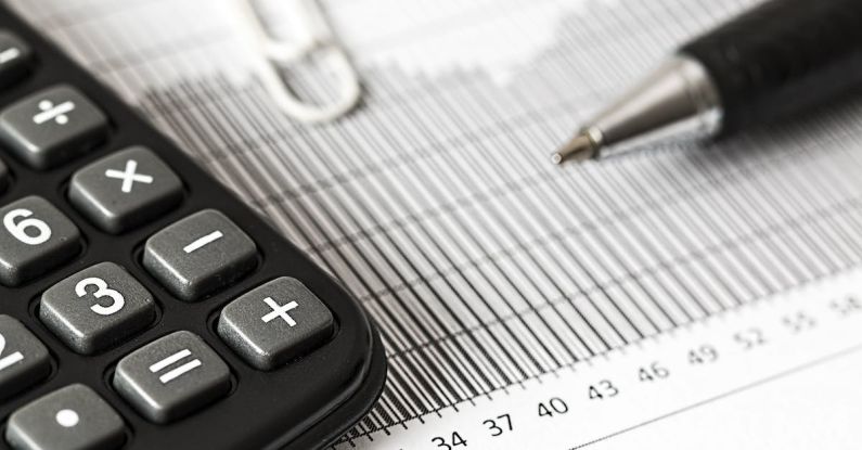 Taxes Investment - Calculator and Pen on Table