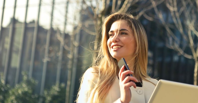 Real Estate Tech - Woman Wearing White Top Holding Smartphone and Tablet