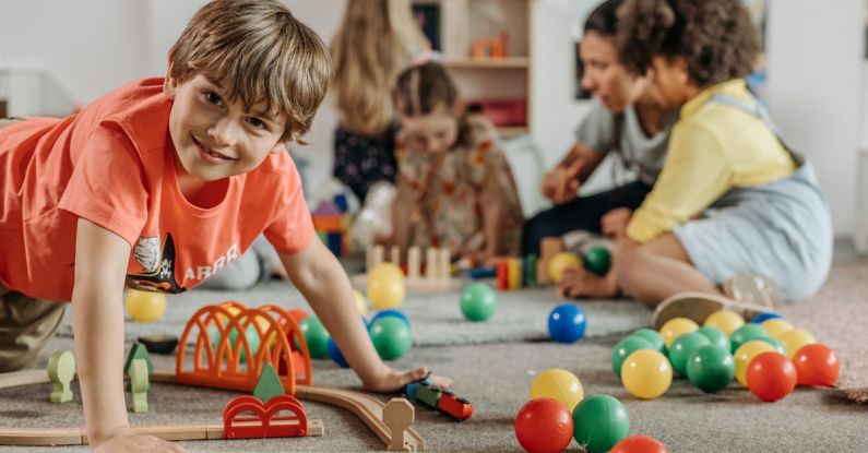 Asset Classes - Boy in Orange Shirt Playing on the Floor