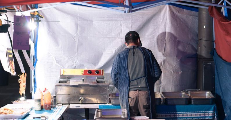 Asian Market - Cook Preparing a Street Food Stand at the Marketplace