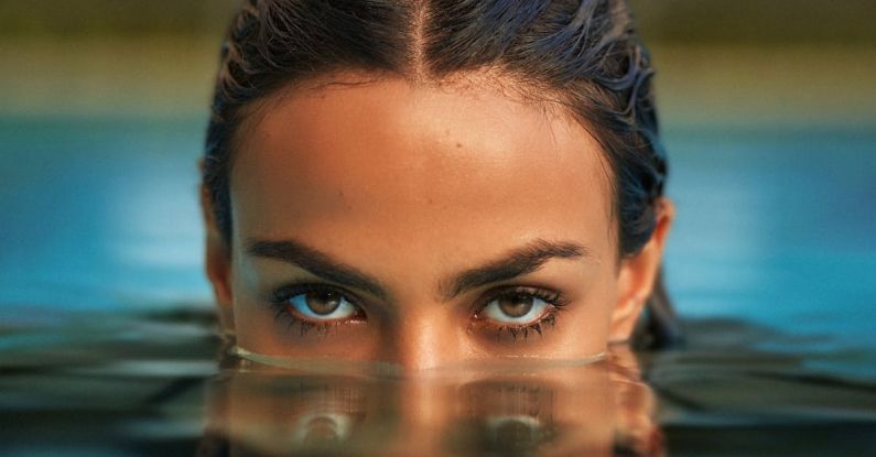 Emerging Markets - Photo of a Woman Emerging from the Water in a Swimming Pool