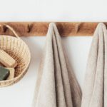Sustainable Challenges - Wooden hanger with towels and basket with bathroom products